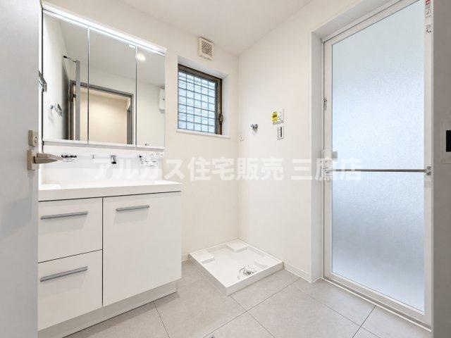 三鷹市深大寺2丁目 中央線 武蔵境駅 中古戸建の独立洗面台|三面鏡付きの洗面化粧台を備えたパウダールーム。室内洗濯機置場も隣接しており、スムーズな家事動線を実現します。