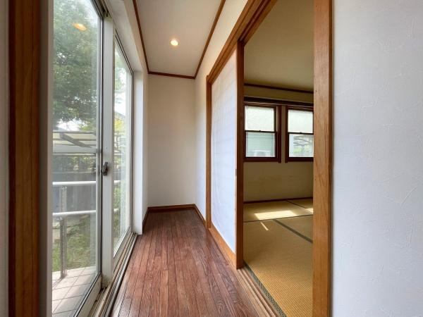 高江南1丁目　戸建ての内装|大きな窓から自然光がしっかり差し込む廊下です。隣接する和室へのアクセスもしやすく開放感があります。フローリングと和室のコントラストが楽しめます。屋外への出入りもスムーズな設計です。