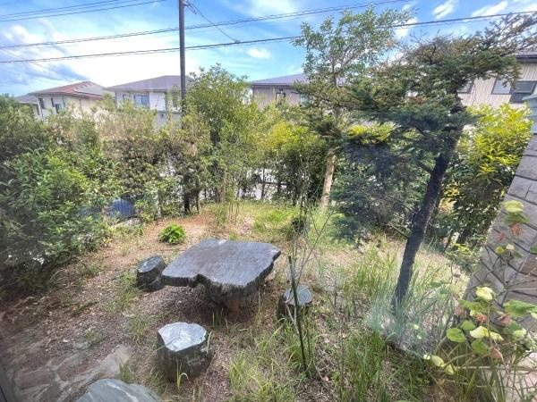 高江南1丁目　戸建ての庭|石のテーブルと椅子が配置された庭は木々や草花に囲まれた開放的な雰囲気です。外からの視線も気になりにくい造りになっています。落ち着いた景観が広がっているのが特徴です。