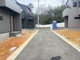 【前面道路含む現地写真】 | 東広島市八本松南5丁目（全8区画）No6 | 敷地前面には幅員約4mの道路を備え、車の出し入れもスムーズです。落ち着いた配色で統一された街並みが整備された落ち着いた住環境です。