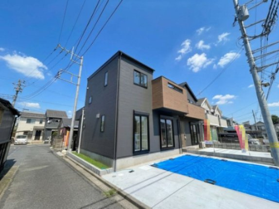 福生市熊川全2棟　1号棟の外観|【1号棟】ブラウンとグレーのツートンカラーがお洒落な新築分譲住宅の外観写真です。 明るい日差しの中で、洗練されたデザインが目を引きます。駐車場スペースもあり、快適な生活が想像できる物件です。