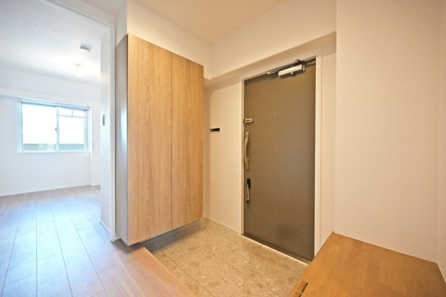 西宮セントポリア1号棟の玄関|足元は石目調で切り替え、すっきりとした印象に仕上げています。玄関横にはカウンターがあり、鍵などの小物を置いたり、季節のインテリアを飾ったりできます。