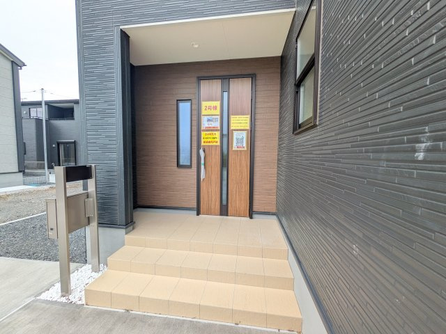 ひたちなか市中根9期　新築戸建　2号棟の玄関|お洒落な玄関ドアと洗練された外壁デザイン。家の顔にふさわしい上質な佇まいで、ご家族やお客様を迎えます。