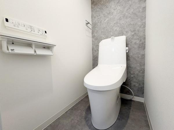 東明野ハイツのトイレ|清潔感のあるデザインのトイレです。シックな色合いの壁と床が空間をすっきりと見せます。