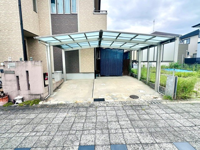 木津川市梅美台2丁目　　中古戸建の駐車場|屋根付きの広い駐車スペースは、雨の日でも濡れずに乗り降りでき、大切な愛車を日差しや汚れから守ります。