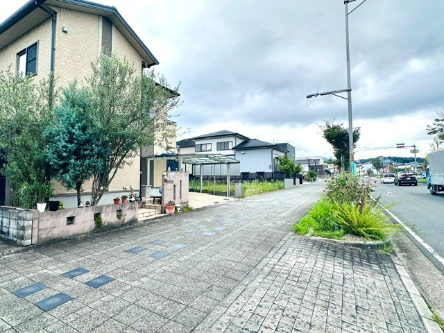 木津川市梅美台2丁目　　中古戸建の前面道路含む現地写真|幅の広いきれいに整備された歩道に面しており、車通りからの安全性にも配慮された立地です。