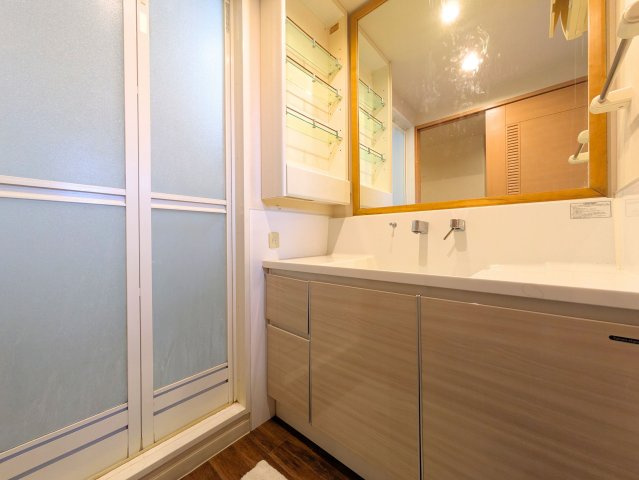 サーパス土居田南の洗面所|温かみのある木目調の洗面台には大きな鏡を備えました。小物もすっきり収まる収納スペース付きです。