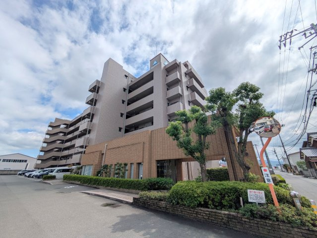 サーパス土居田南の外観|落ち着いた色調のタイル貼りの外観デザイン。整えられた緑豊かな植栽が、住まう人を心地よく出迎えます。