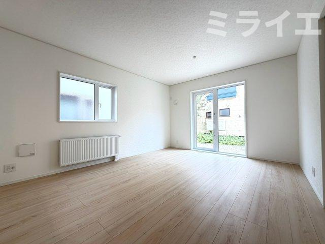【新築戸建】江別市大麻東町2棟の居間・リビング|リビングが見渡せる対面キッチンを採用。内装(壁・床・建具)は白を基調とし、明るい雰囲気となっています。(1号棟)