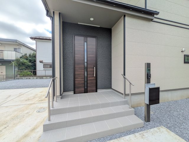 つくば市高野台3丁目10番　新築戸建　A号棟の玄関|お洒落な玄関ドアと洗練された外壁デザイン。家の顔にふさわしい上質な佇まいで、ご家族やお客様を迎えます。