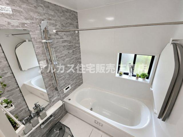 【内覧動画公開中！】三鷹市上連雀7丁目 中央線 三鷹駅 新築戸建の浴室|シックなアクセントパネルがおしゃれなユニットバス。窓から明るい光が差し込み、ゆったりとした浴槽で心地よいバスタイムを過ごせます。（※家具・調度品等は販売対象外です）