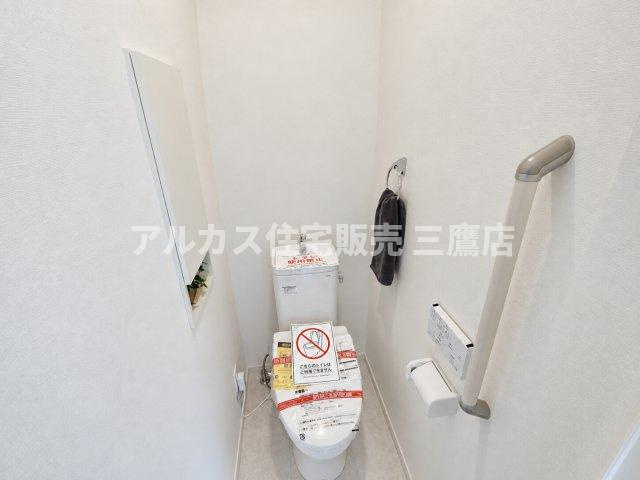 【内覧動画公開中！】三鷹市上連雀7丁目 中央線 三鷹駅 新築戸建のトイレ|安心感のある手すりが設置されたバリアフリー配慮のトイレ。壁面には埋め込み式の収納スペースも確保されています。（※家具・調度品等は販売対象外です）