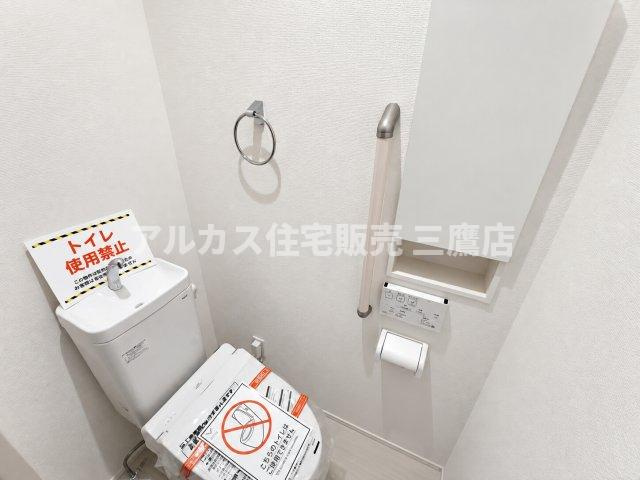 【内覧動画公開中！】三鷹市上連雀7丁目 中央線 三鷹駅 新築戸建のトイレ|立ち座りをサポートする手すりや、小物をすっきりしまえる埋込型収納棚を備えた、優しさと使いやすさを両立したトイレです。 