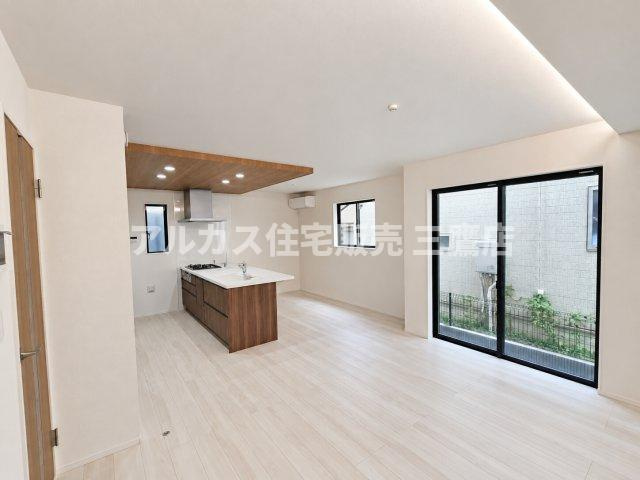 【内覧動画公開中！】三鷹市上連雀7丁目 中央線 三鷹駅 新築戸建の居間・リビング|折り上げ天井の間接照明と開放的な窓が演出する明るいLDK空間。キッチン上の下がり天井が空間のアクセントになっています。
