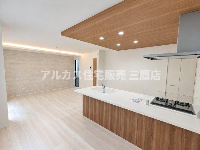 【内覧動画公開中！】三鷹市上連雀7丁目 中央線 三鷹駅 新築戸建の居間・リビング|木目調の下がり天井が印象的な対面キッチン空間。手元の作業スペースが広く、料理をしながら家族と会話が弾みます。