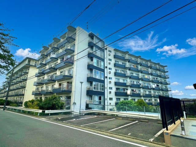 上大岡ハイツC棟の外観|外観は7階建ての白亜のフォルムで、各戸とも住戸とは別に専用物置が設置されています。周辺は戸建住宅が整然と建ち並ぶ住宅街の一角で、南側は公園に隣接していて日当たり良好です。