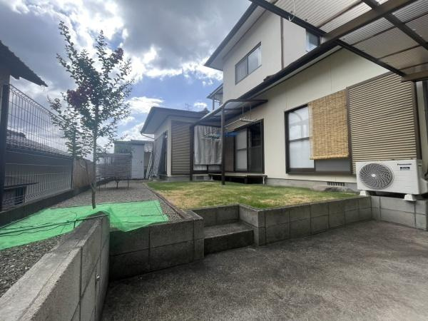 星和台一丁目　戸建ての庭|住まいに調和した庭が広がっておりコンクリート部分と芝生スペースが分かれています。フェンスに囲まれた安心感のある庭空間です。