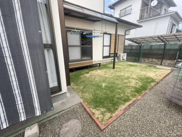 星和台一丁目　戸建ての庭|芝生が敷かれた庭が広がり落ち着いた雰囲気が感じられます。物干しスペースも確保されており日当たりも良好です。周囲はフェンスで囲われており視線を気にせずに使えます。屋根付きのスペースもあるので便利です。