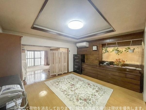 星和台一丁目　戸建ての居間・リビング|天井のデザインが印象的で落ち着いた雰囲気を演出しています。壁面のデザインがアクセントとなっており落ち着いた雰囲気が広がります。ゆとりのある広さが魅力で家具の配置も自由に楽しめます。