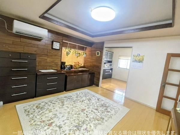 星和台一丁目　戸建ての居間・リビング|落ち着いた色調のフローリングと木目のアクセント壁が調和したリビングです。広々とした空間で家具の配置がしやすい間取りになっています。天井の照明も明るさをしっかり確保しており快適に過ごせます。