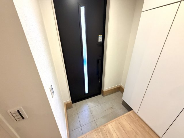 越谷市蒲生１７期ケイアイグレイス　新築戸建の玄関|明るい照明と清潔感のあるタイル床が印象的。来客時にも心地よい第一印象を与えてくれます。