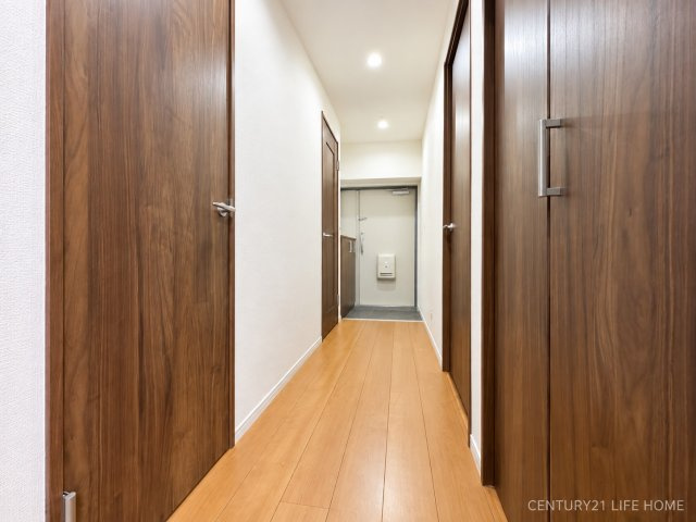 【その他共用部分】 | 読売ランド前ハイデンス | 明るい木目のフローリングと落ち着いた色合いの建具が調和した廊下。すっきりとした内装で、各居室へスムーズにつながる生活動線にも配慮された空間です。