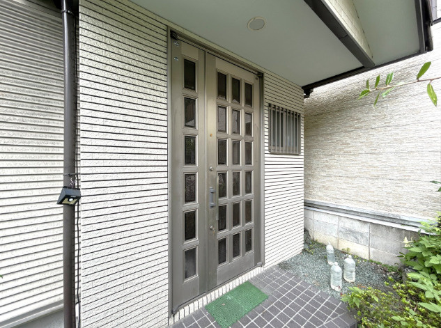 「サウナ付×2世帯対応」高知市円行寺　中古一戸建ての玄関|重厚感あふれる格子のデザインが目を引く玄関ドア。住まいの顔として上質な佇まいを演出します。