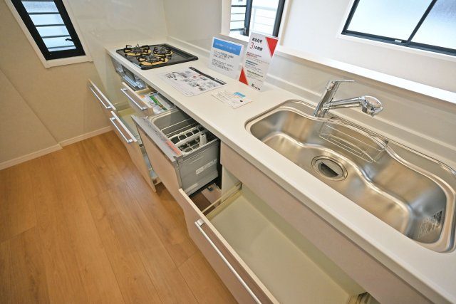 尼崎市西難波町4丁目中古一戸建て│5LDK+駐車1台可のキッチン|食洗機付きシステムキッチンを導入。調理台下いっぱいに収納を設け、包丁のホルダーや調味料専用の引き出しも備えています。