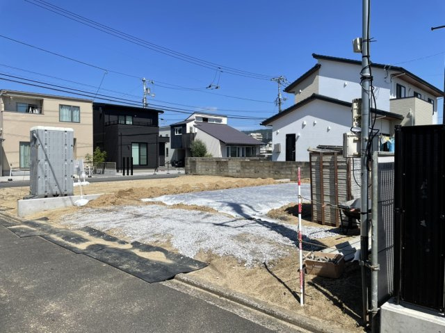 松山市今在家2丁目　新築戸建の前面道路含む現地写真|造成が整い建物の完成を待つ現地の状況。周辺は坂道が少なく歩きやすい平坦なエリアで、陽当たりの確認や現地周辺の落ち着いた生活環境をご自身の目で直接お確かめいただけます。