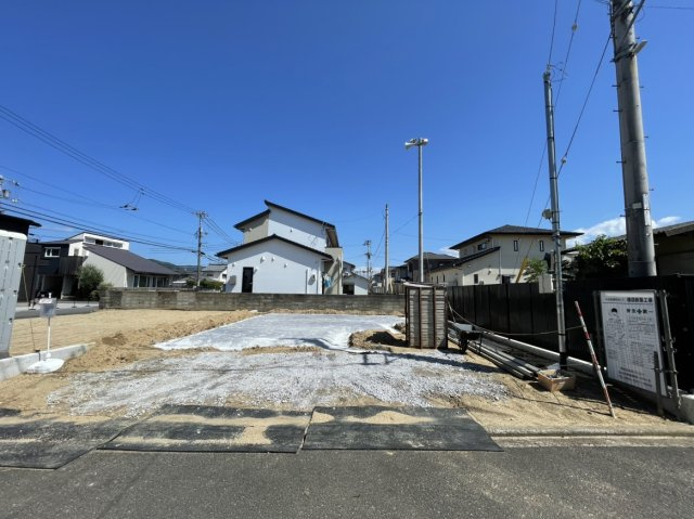 松山市今在家2丁目　新築戸建の前面道路含む現地写真|建築予定地である現地の良好な景観。前面道路からの見通しも良く、実際に現地に立つことで土地の広がりや風通しの良さを体感することが可能です。