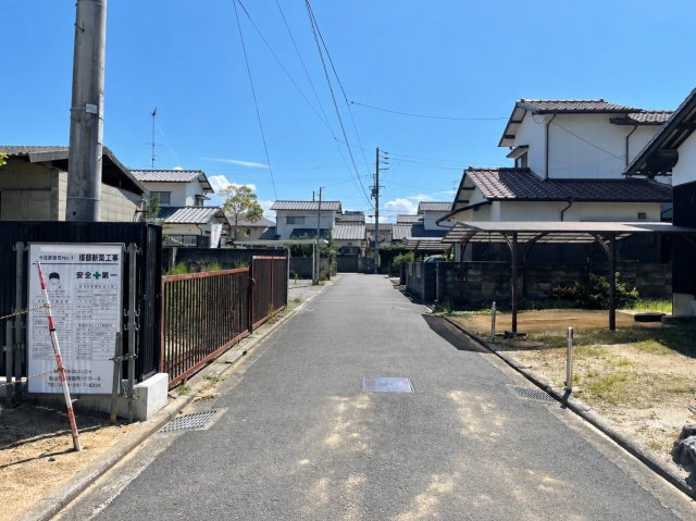 松山市今在家2丁目　新築戸建の前面道路含む現地写真|見通しが良く落ち着いた通行が可能なフラットな前面道路。接道幅が約9.7mあるため駐車時の切り替えもしやすく、自転車やベビーカーでの移動もスムーズに行える安心の道路設計です。