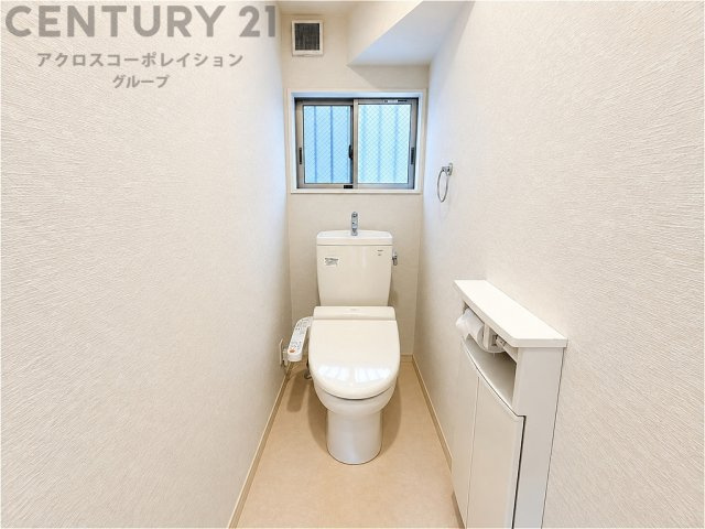窓付きで自然光と換気を確保した、清潔感のあるトイレ空間。温水洗浄便座を備え、収納スペースも確保されているため、生活感を抑えてすっきりとお使いいただけます。