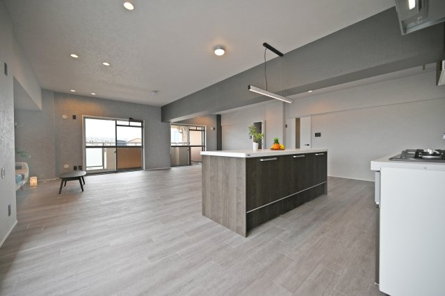 セントラル朝日が丘の居間・リビング|開放感とデザイン性を兼ね備えたアイランドキッチンを採用したLDK。キッチンを中心に家族が自然と集まりやすく、料理をしながら会話も楽しめる空間です。回遊しやすい動線で家事のしやすさにも配慮されています。