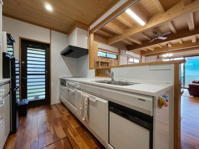 大村市赤佐古町の中古一戸建のキッチン|食洗器付きのシステムキッチンです。キッチン横の勝手口は裏庭に繋がっており、ゴミ出しの動線としても便利です。
※画像は生成AIを用いて加工したものであり、一部実物と異なる箇所がございます。