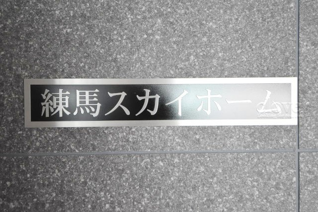 【現況写真】 | 練馬スカイホーム | エントランスに掲げられた、マンション名を示す館銘板。さほど激しく主張はしませんが、しっかりと掲示されています。～即日のご見学可能～　お問合せはお気軽にどうぞ。

