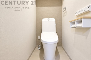 落ち着いた色合いでまとめられた、清潔感あふれるトイレ空間。温水洗浄便座を備え、収納棚も設置。すっきりとした内装で、毎日気持ちよくお使いいただけます。