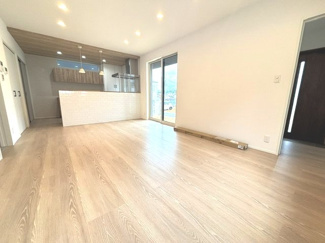 【居間・リビング】 | 東広島市八本松南5丁目（全8区画）No7 | 広々とした17帖のLDKスペース。木目調の天井アクセントクロスと清潔感のある内装が特徴です。対面式キッチンからはリビング全体を見渡せる開放的な配置となっています。