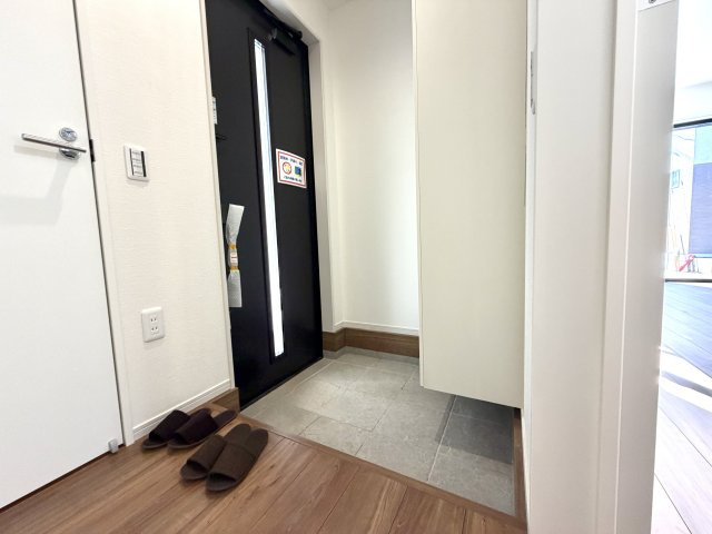 越谷市東大沢７期１号棟ケイアイグレース　新築戸建の玄関|明るい照明と清潔感のあるタイル床が印象的。来客時にも心地よい第一印象を与えてくれます。