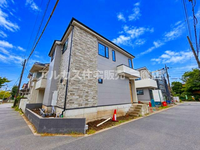 小金井市貫井南町1丁目 中央線 武蔵小金井駅 新築戸建の外観|角地側から全体を見渡したカットです。側面に施された石目調デザインの質感が際立っており、前面道路と敷地の位置関係がよく分かります。