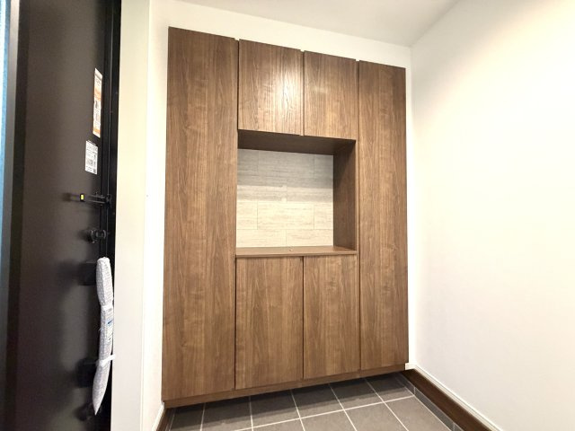 越谷市大竹１号棟　新築戸建の玄関|スタイリッシュな取っ手レスデザインのシューズボックス。玄関全体にすっきりとした高級感を与えます。