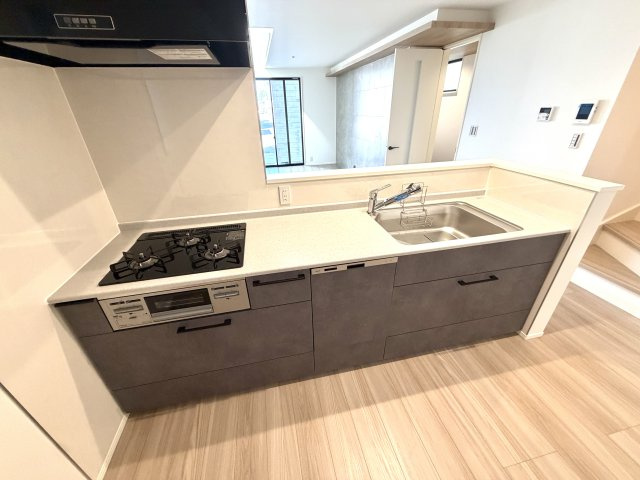 越谷市大竹２号棟　新築戸建のキッチン|リビング全体を見渡せる開放的なキッチン配置。小さなお子様やペットの様子を見守れて安心です。