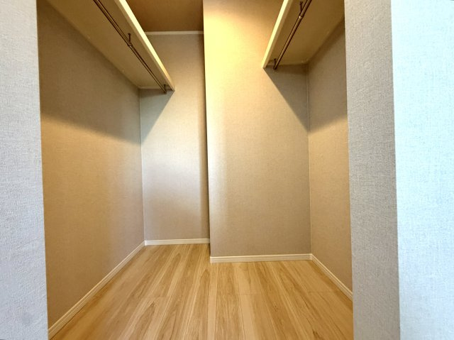 越谷市花田６丁目A号棟　新築戸建の収納|内部に照明を備えた明るいウォークインクローゼット。奥の荷物や服の色味もハッキリ確認できます。