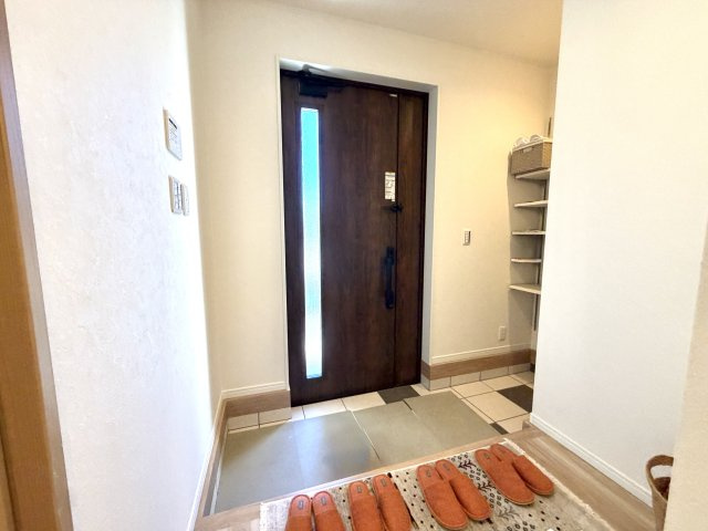 越谷市花田６丁目E号棟　新築戸建の玄関|明るい照明と清潔感のあるタイル床が印象的。来客時にも心地よい第一印象を与えてくれます。