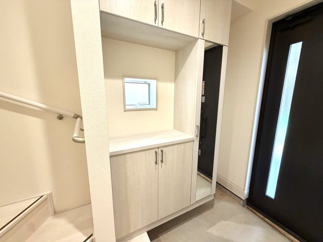 越谷市蒲生東町２期１号棟　新築戸建の玄関|傘立てスペースやフックを備えた多機能シューズボックス。玄関周りの小物がサッと片付きます。