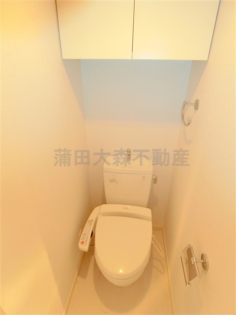 コンシェリア大森山王のトイレ|吊戸棚と温水洗浄便座付きのトイレ