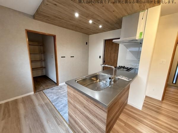 杉原　戸建てのキッチン|木目調のデザインで統一されたキッチンは落ち着いた雰囲気が感じられます。作業スペースが広めで収納棚も使いやすい配置です。シンプルなレイアウトで使い勝手にも配慮されています。