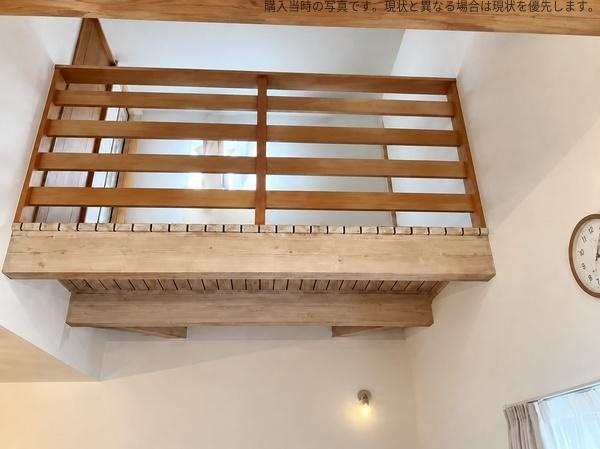 梅が丘　戸建てのその他|吹き抜けに面した木製の手すりが温かみのある雰囲気を演出します。梁や天井の高さが空間に開放感を与えています。ナチュラルな木目調が室内によく調和しています。