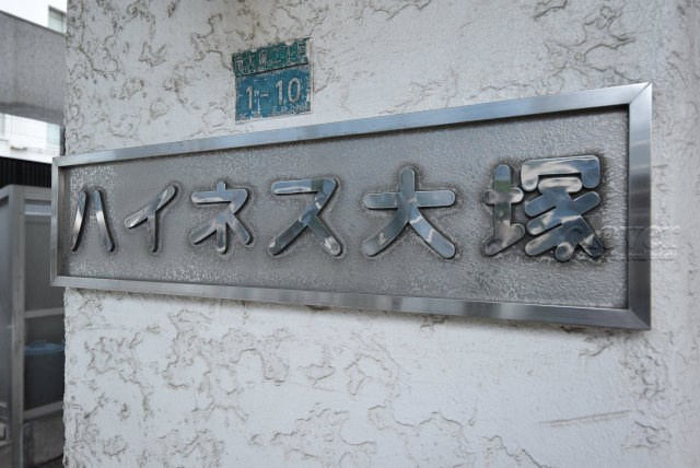 【現況写真】 | ハイネス大塚 | エントランスに掲げられた、マンション名を示す館銘板。さほど激しく主張はしませんが、しっかりと掲示されています。～即日のご見学可能～　お問合せはお気軽にどうぞ。