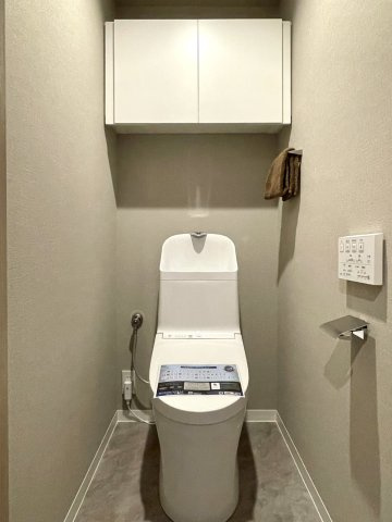 ハウステンボスヒルズ1のトイレ|収納に便利な吊戸棚付きのサニタリーです。