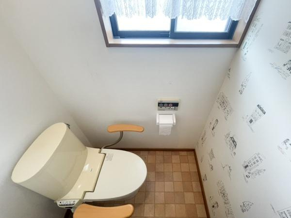 口戸　戸建てのトイレ|窓付きで自然光が入るトイレです。操作パネル付きの洗浄機能付きトイレが設置されています。